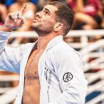 Vinicius Lessa com o braço erguido após vencer luta em campeonato da IBJJF