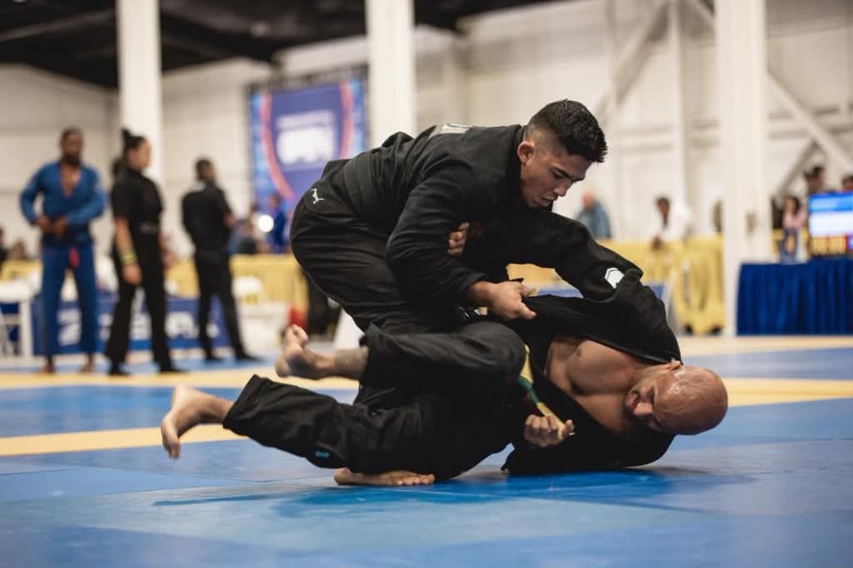 Andy Murasaki submits both opponents, rolls into The Crown 1 Andy Murasaki, in a black gi, on top of his opponent at the Orange County Fall Open