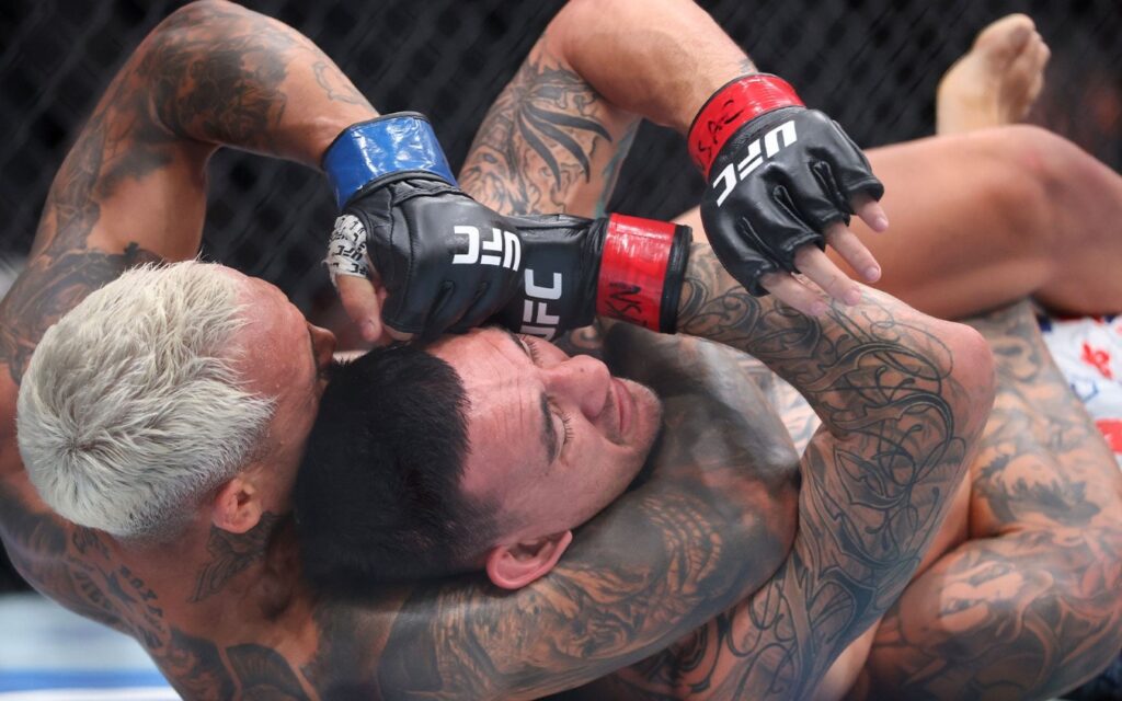 Charles do Bronx ameaça largar cinturão BMF antes do UFC 335 1 Charles do Bronx tenta um mata-leão em Max Holloway no chão do Octógono no UFC 326