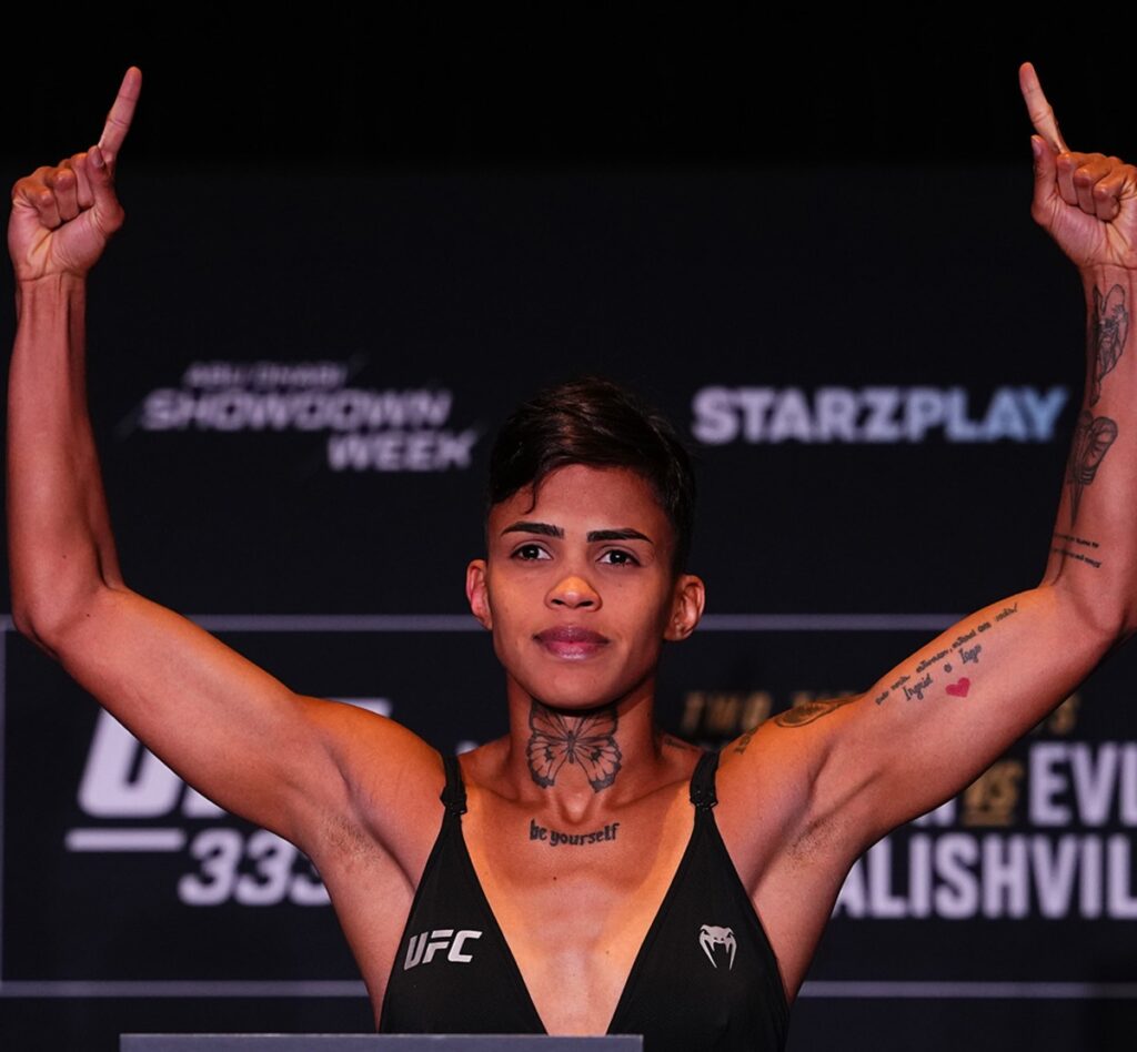 Iasmin Lucindo de top preto, com os braços erguidos, na pesagem oficial do UFC 333 em Abu Dhabi