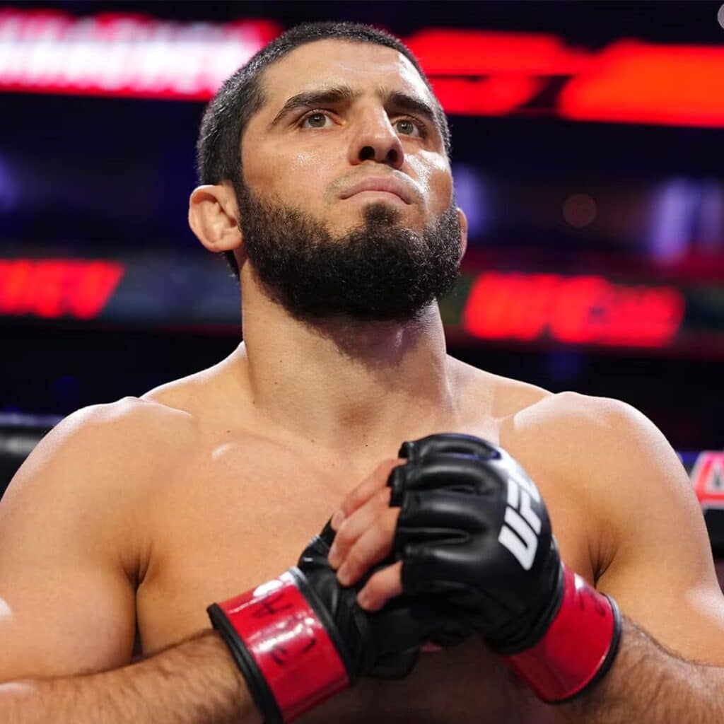 Islam Makhachev diz que próxima luta é uma das últimas 1 Islam Makhachev de luvas no octógono, com as mãos juntas na altura do peito, no UFC 330