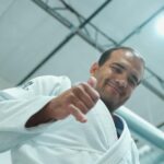 Márcio André: “A coisa mais difícil é vencer alguém que nunca desiste de evoluir” 12 Márcio André de kimono branco faz sinal de positivo