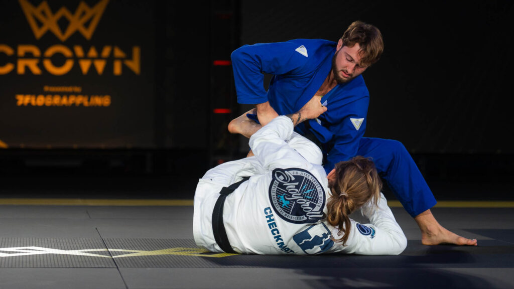 Nolan Stuart returns to The Crown to defend his title and completes the heavyweight bracket 1 Nolan Stuart, in a blue gi, attacks an omoplata on Adam Wardzinski in the 2025 Crown final