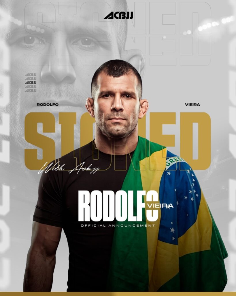 Rodolfo Vieira assina com o ACBJJ 1 Rodolfo Vieira, de camiseta preta e com a bandeira do Brasil no ombro, na arte de anúncio do ACBJJ