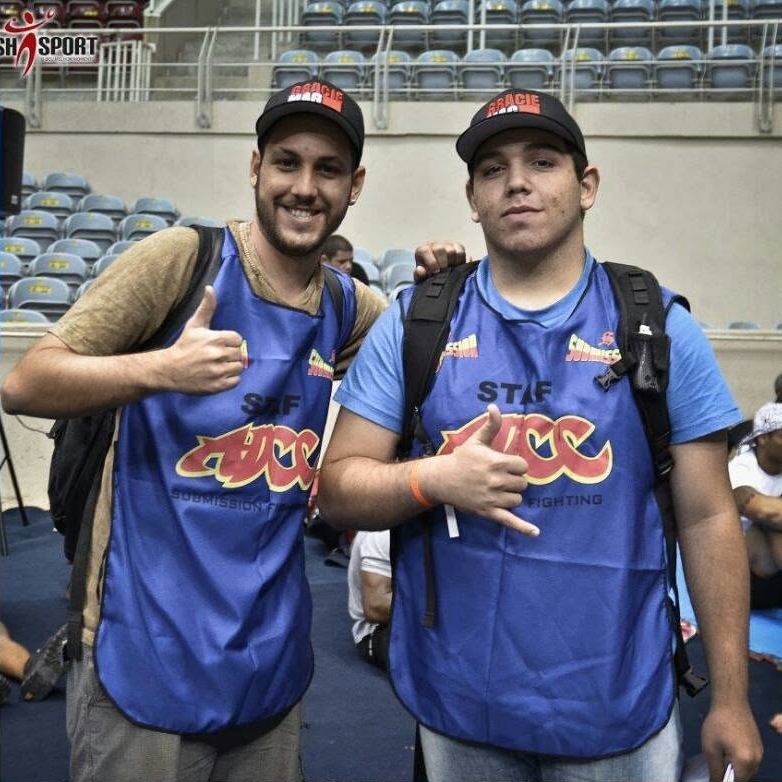 Vitor Freitas e Carlos Arthur Jr. com colete do ADCC e boné da GRACIEMAG