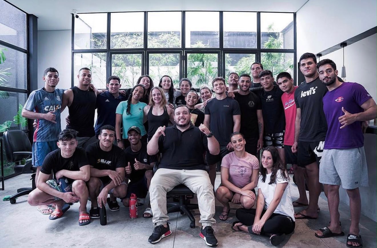 Vitor Freitas sentado ao centro, cercado pelos atletas da Dream Art, em São Paulo